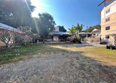 Spacious outdoor area with natural surroundings and buildings in the background