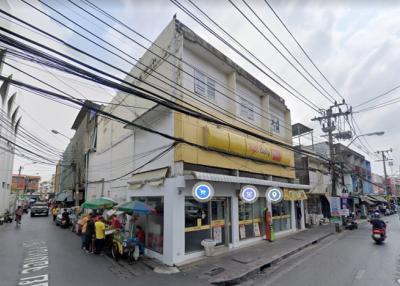 Street view of a two-story corner building with commercial space on the ground floor