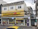 Street view of a mixed-use building with commercial space on the ground floor