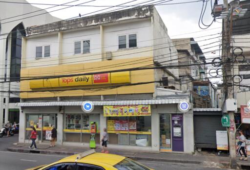 Street view of a mixed-use building with commercial space on the ground floor