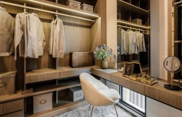 Modern walk-in closet with built-in wardrobes and an elegant chair