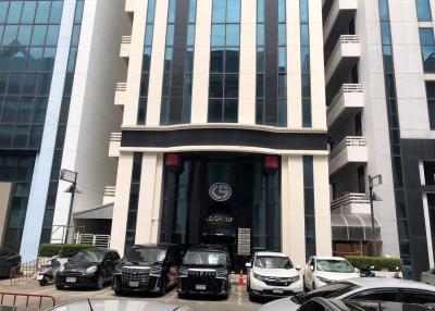 Modern office building facade with parked cars