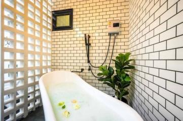Modern bathroom with white brick-style tiles and freestanding bathtub