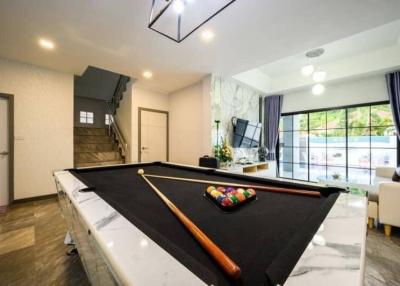 Spacious living room with pool table and abundant natural light