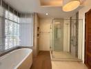 Bright modern bathroom with separate bathtub and walk-in shower