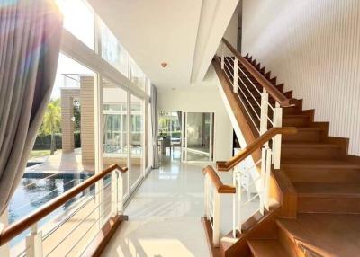 Bright and spacious home interior with staircase and pool view