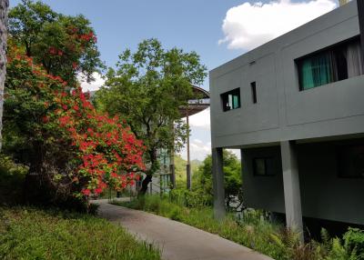 Modern house with lush greenery and blooming red flowers