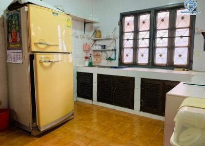 Spacious kitchen with vintage refrigerator and tiled flooring