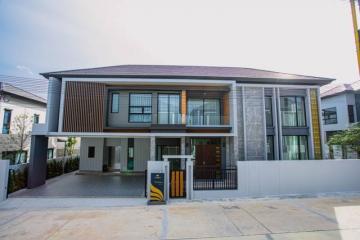 Modern two-story house with stone wall accents and balcony