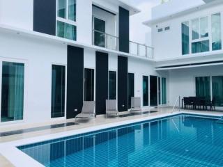 Modern white two-story house with swimming pool and outdoor relaxation area