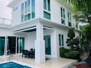 Modern two-story house with a swimming pool and outdoor dining area