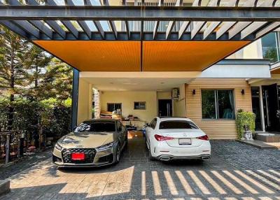 Modern house exterior with a spacious driveway and two parked cars
