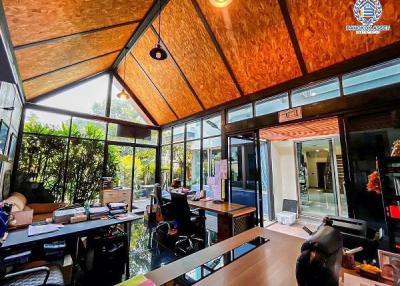 Spacious home office with glass walls and wooden ceiling