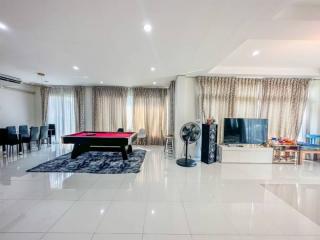 Spacious modern living room with a pool table, entertainment area, and dining space