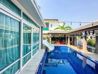 Spacious outdoor pool with a slide and patio area