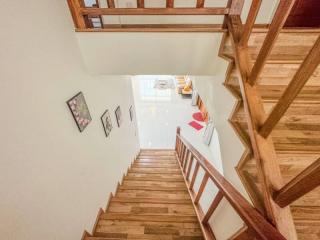 Wooden staircase with white walls and artwork in a modern home