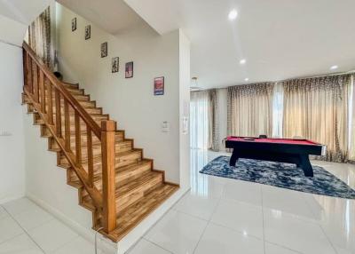 Elegant living space with staircase and pool table