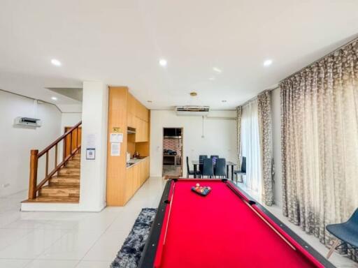 Spacious living room with billiard table and open kitchen