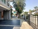 Spacious exterior of a residential building with tiled walkway and greenery