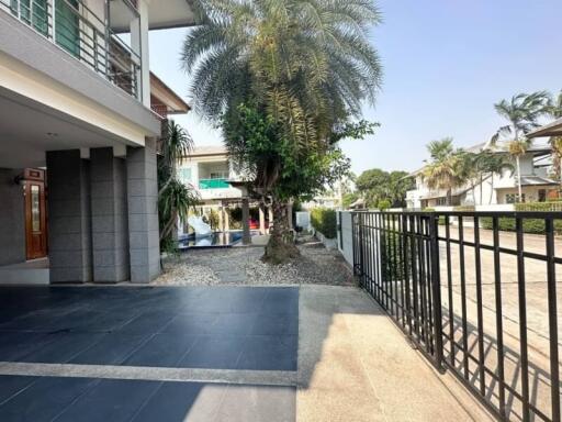 Spacious exterior of a residential building with tiled walkway and greenery