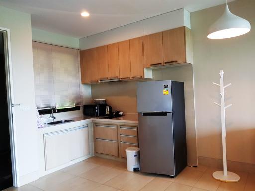 Modern kitchen with wooden cabinets and stainless steel refrigerator