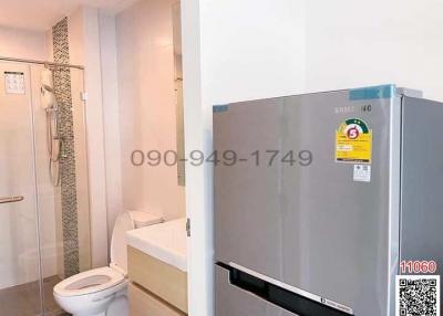 Compact bathroom with adjacent laundry area featuring modern appliances