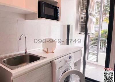 Modern compact kitchen with stainless steel appliances and window