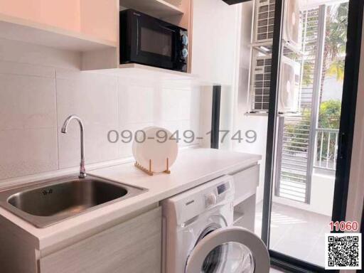 Modern compact kitchen with stainless steel appliances and window