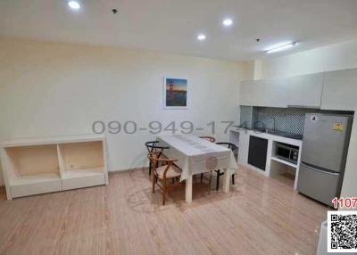 Spacious combined living room and kitchen with modern appliances and dining set