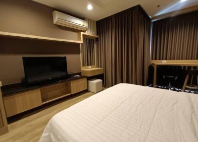 Modern bedroom with a large bed and entertainment unit
