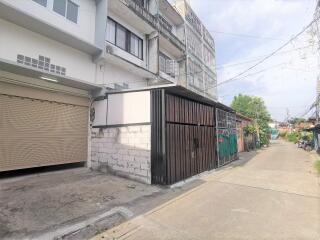 Street view of a residential building with garage and gated entrance