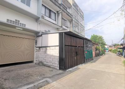 Street view of a residential building with garage and gated entrance