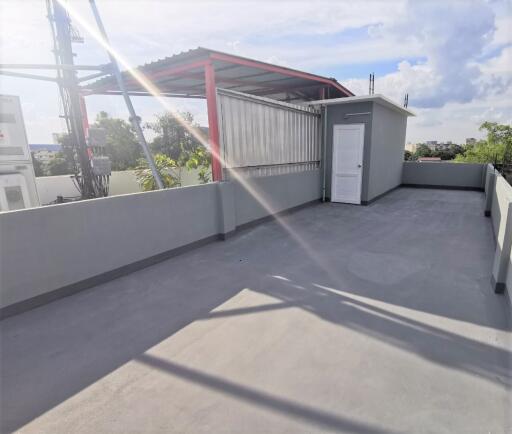 Spacious rooftop area with utility shed and open sky view