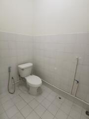 White tiled bathroom with a toilet and bidet