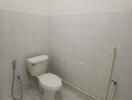 White tiled bathroom with a toilet and bidet