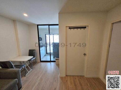 Compact living room with balcony access and ample natural light