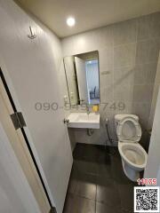 Compact modern bathroom with tiled walls and essential fixtures