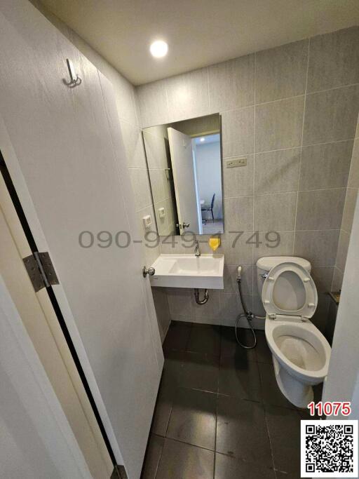 Compact modern bathroom with tiled walls and essential fixtures