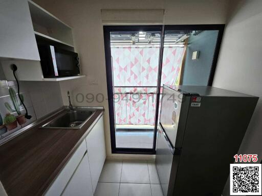 Modern kitchen interior with glass door and patterned curtain