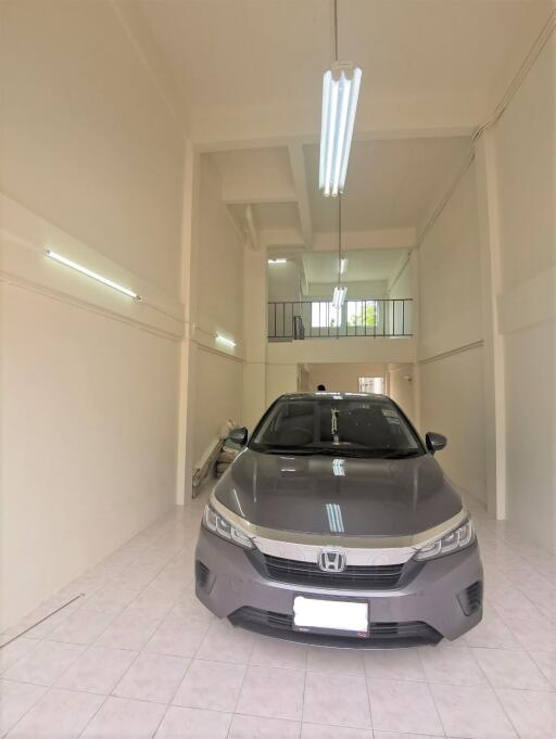 Modern home garage with a vehicle and fluorescent lighting