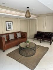 Elegant neutral-toned living room with leather sofas and a glass-top coffee table