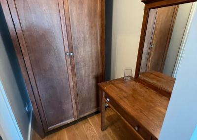 Compact bedroom with wooden wardrobe and writing desk