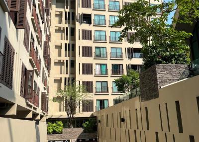 Exterior view of a modern residential apartment building with balconies and a clear blue sky