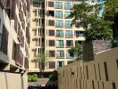 Exterior view of a modern residential apartment building with balconies and a clear blue sky