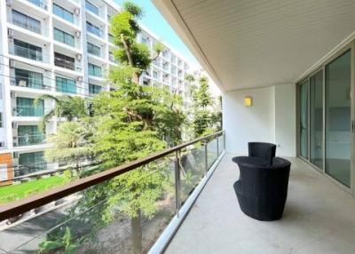 Spacious balcony with modern furniture and a view of apartment complex gardens