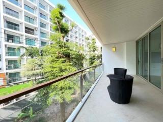 Spacious balcony with modern furniture and a view of apartment complex gardens