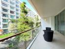 Spacious balcony with modern furniture and a view of apartment complex gardens