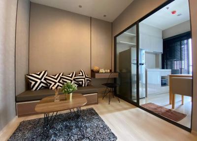 Modern living room with comfortable seating and glass door leading to another room