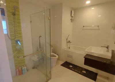 Modern bathroom interior with glass shower enclosure, vanity, and toilet