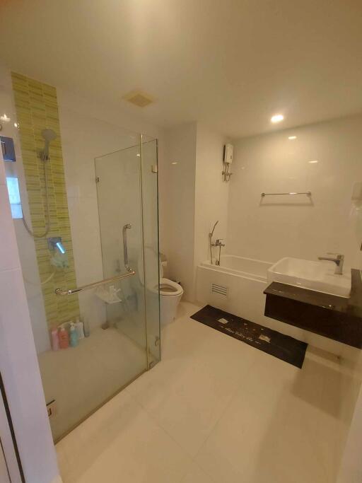 Modern bathroom interior with glass shower enclosure, vanity, and toilet